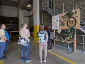 Besuchergruppe betrachtet eine Schautafel mit Fremdstoffen aus dem Grüngut in der Biogasanlage Telli in Aarau