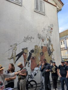 Stadtführung in der Aarauer Altstadt vor einer historischen Fassadenmalerei